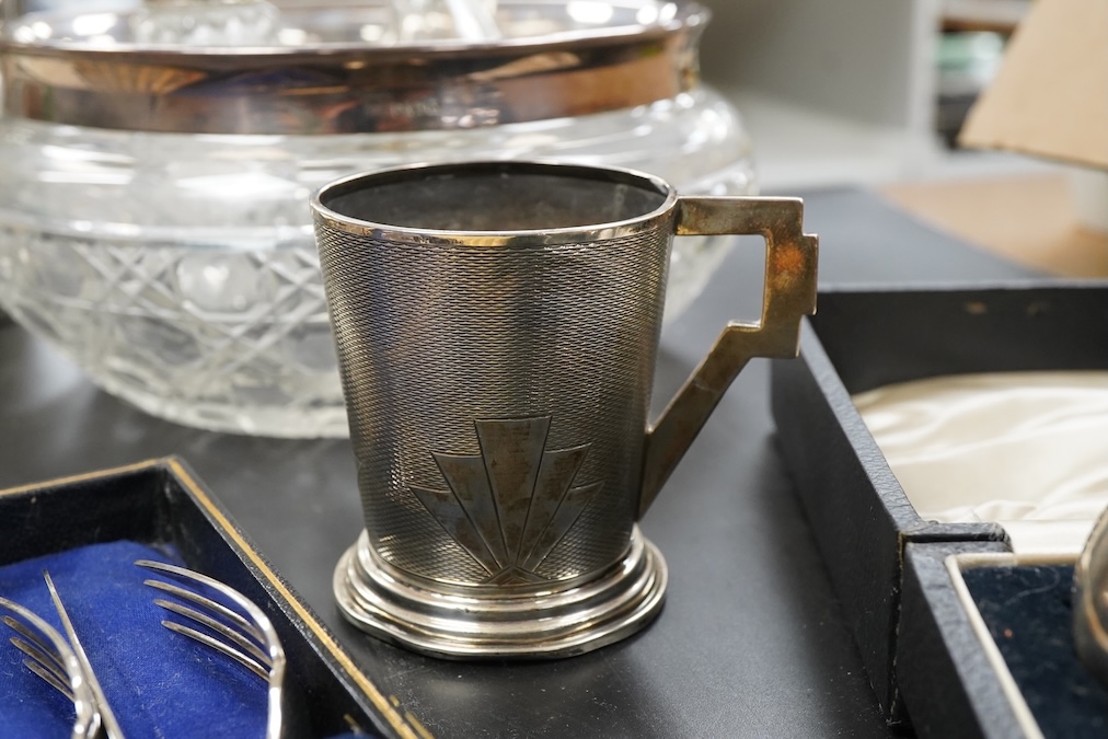A silver christening mug, Birmingham, together with three cased sets, silver rimmed cut glass bowl, plated cocktail shaker etc